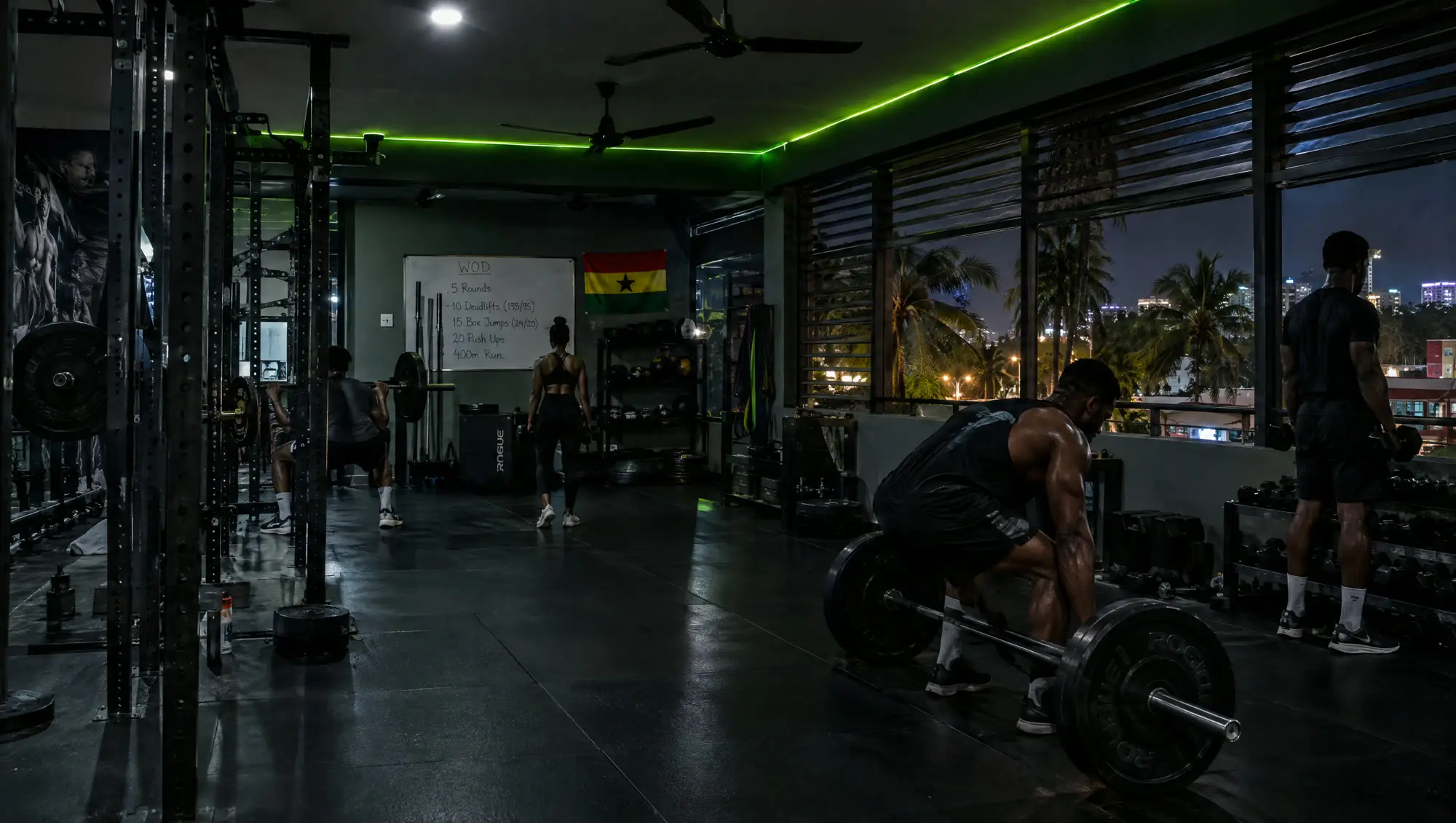 The Ahoɔden gym floor at night in Labone, racks and members training under a lime strip light